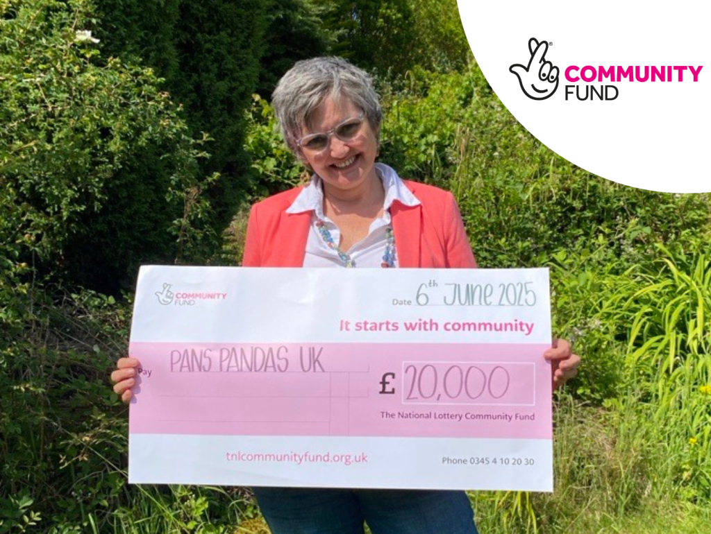 Our CEO holding a cheque for £20,000, from the National Lottery Community Fund.